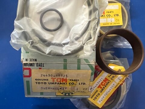 Box of automotive bearing kit with circular seals and rings in plastic bags on a blue surface; visible labels say Made in Japan and Toyo Umpanki Co., Ltd.