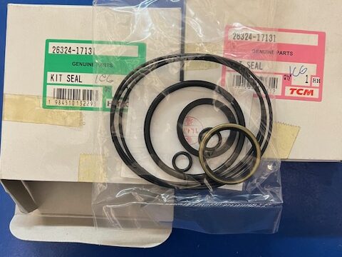 Seal kit with black O-rings in a clear bag atop two boxes labeled 'Genuine Parts' and 'Kit Seal.'